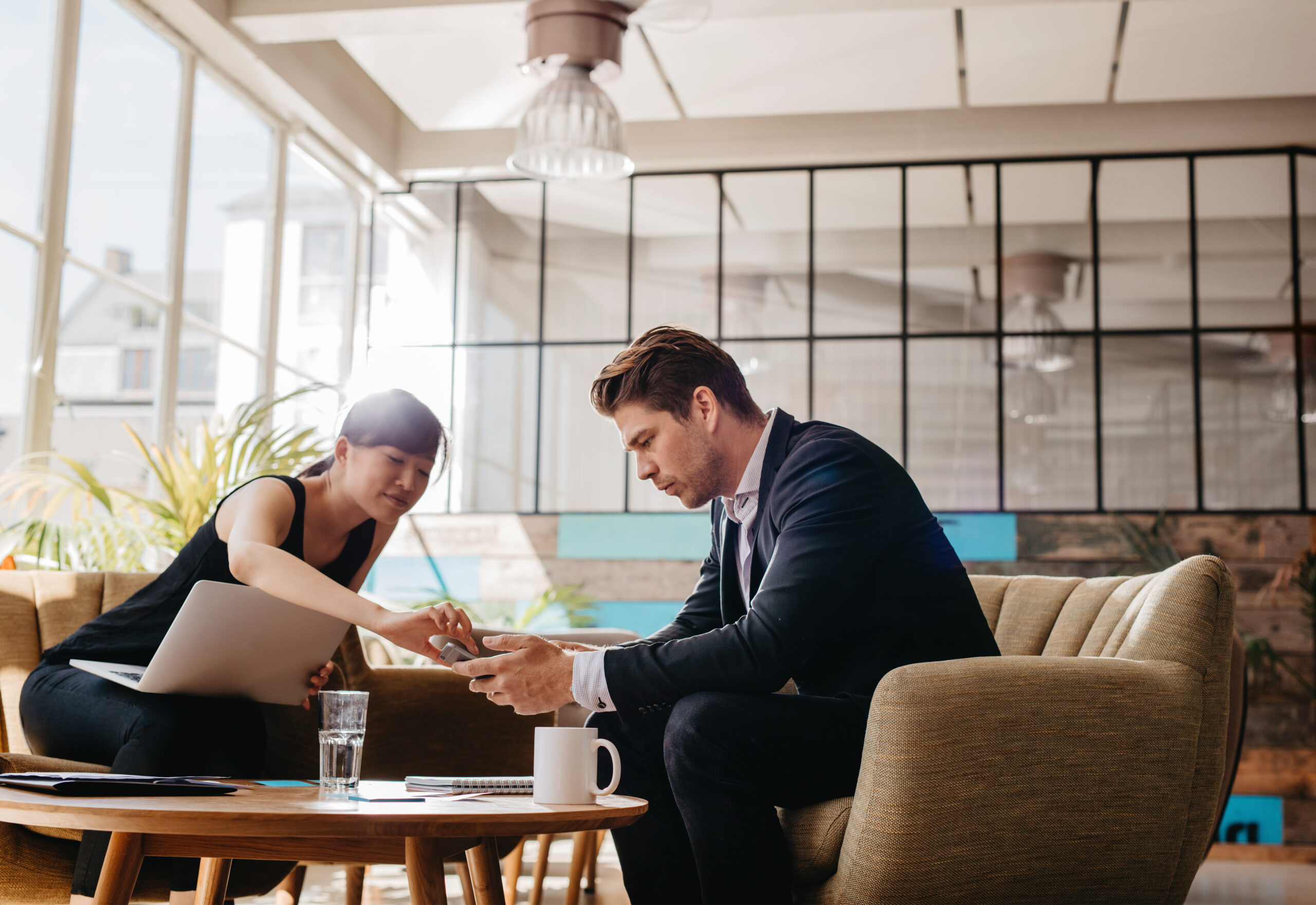 Shot,Of,Two,People,Sitting,In,Office,Lobby.,Business,Partners